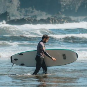 man with surf board on the beach